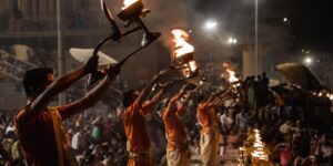 Devotees participating in Ganga Aarti, enjoying peaceful riverside walk, and engaging in cultural workshop activities at a spiritual retreat.