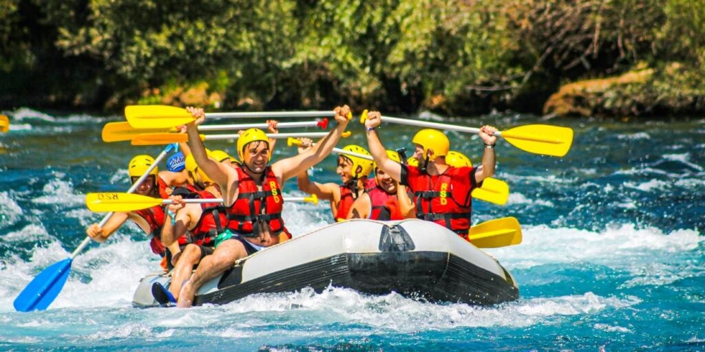Group participating in rafting, playing team sports, and enjoying a bonfire during a team adventure challenge at an outdoor camp