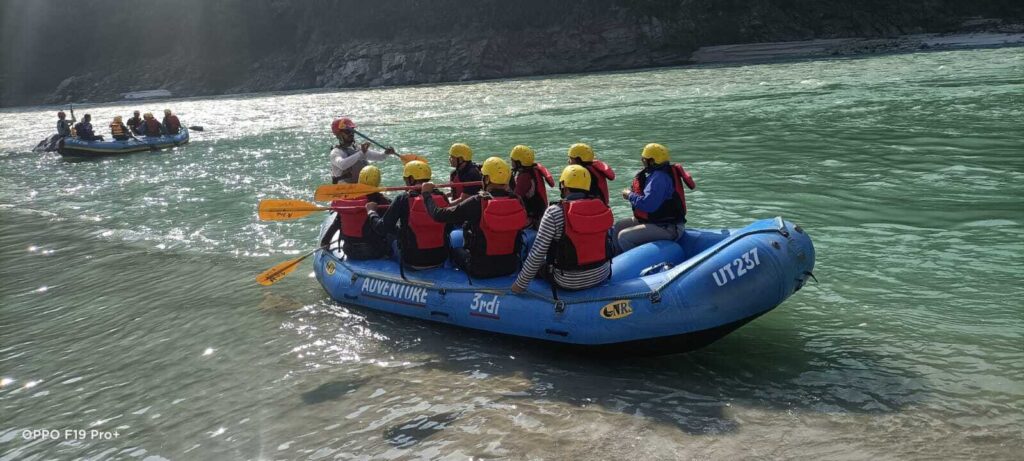 Group enjoying thrilling river rafting adventure on the Ganga River with Ganga Beach Camp in Rishikesh.
